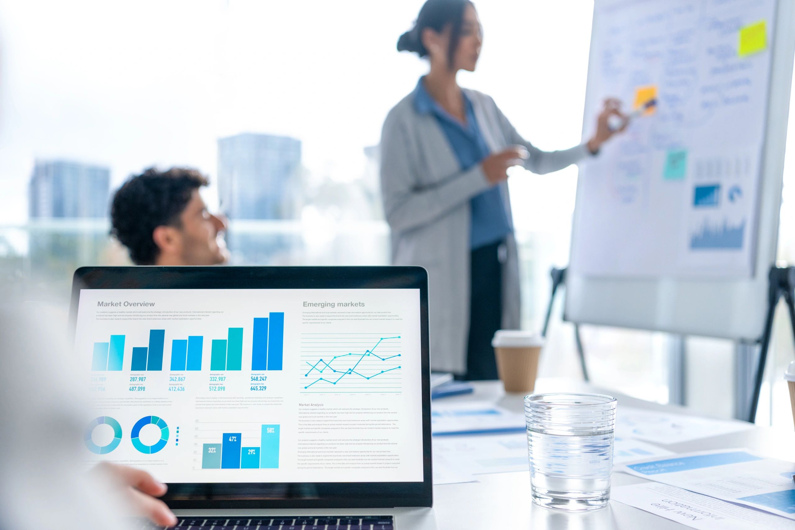 Business presentation with charts and graphs on a whiteboard
